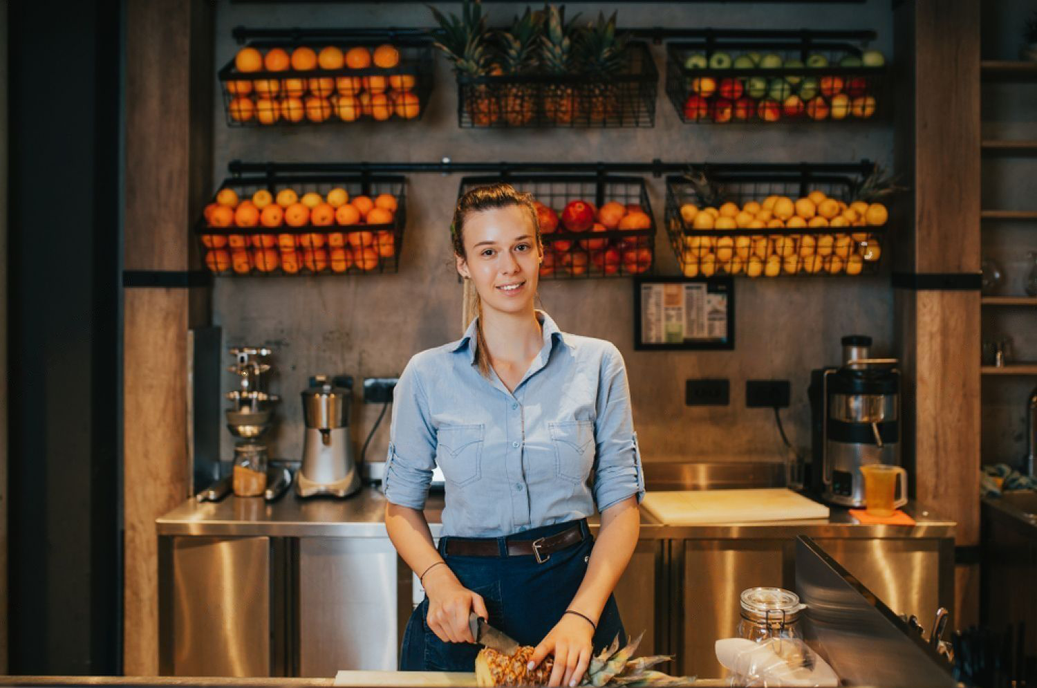 Bartender som skjærer i en annanas